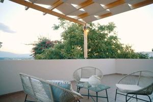 two chairs and a table on a patio at Villa Apaggio in Plaka