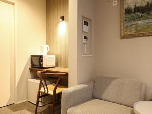 a small room with a chair and a microwave at GRAND BASE Hakataminami in Fukuoka