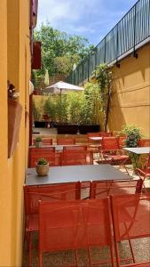 un patio al aire libre con mesas, sillas, mesa y sillas en Résid'Artel Cadarache - ITER en Saint-Paul-lez-Durance