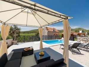 a view of a villa with a pool and an umbrella at Stone House Prapatna in Smokvica