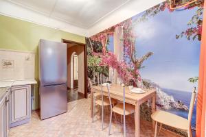 a kitchen with a refrigerator and a table with chairs at Welcome Home Apartments Liteyniy 10 in Saint Petersburg