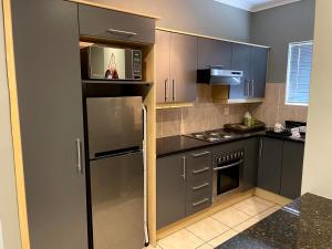 a kitchen with a stainless steel refrigerator and a microwave at The CoziPlace in Cape Town