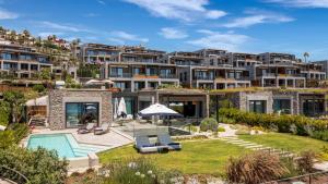 an exterior view of a large apartment building with a swimming pool at Kaya Palazzo Resort & Residences Le Chic Bodrum in Bodrum City