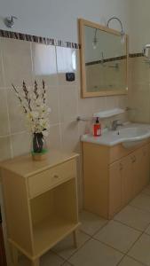 a bathroom with a sink and a vase of flowers at Hotel Casas do Sol in São Filipe