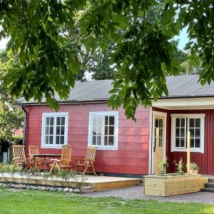 une maison rouge avec des chaises devant elle dans l'établissement Magnarp Strandbad, à Vejbystrand