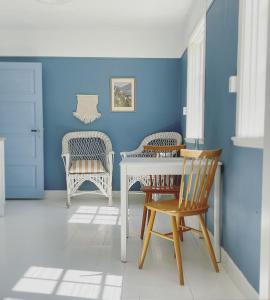 Habitación azul con mesa blanca y sillas en Magnarp Strandbad, en Vejbystrand