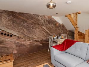 a living room with a couch and a stone wall at The Old Mill Bake House in Ross on Wye
