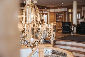 a chandelier hanging from the ceiling in a restaurant at Superior Hotel Schneider Ski-in & Ski-out in Obertauern