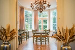 a dining room with a table and chairs and a chandelier at Klein Soestdijk in Veenhuizen