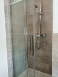 a shower with a glass door in a bathroom at Apartment No 8 - Stay in style in the heart of the Cathedral City. in Truro