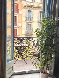 une porte ouverte sur une terrasse avec une table sur un balcon. dans l'établissement Barcelona Central Apartments, à Barcelone