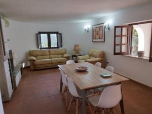 a living room with a wooden table and chairs at Villa magaggiari 1 in Cinisi