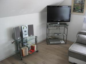 Ferienwohnung H. Broschinski في أوريتش: غرفة معيشة مع تلفزيون بشاشة مسطحة وأريكة