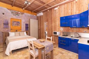 a bedroom with a bed and a table and a kitchen at La Pollona 1817 in San Maurizio Canavese