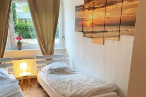 1 dormitorio con 2 camas individuales y ventana en Workers Apartment Bergisch Gladbach Bensberg, en Bergisch Gladbach