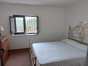 a bedroom with a bed and a window at Villa magaggiari 1 in Cinisi