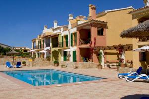 uma casa com piscina em frente a uma casa em Balcón d'es Trenc em Sa Ràpita