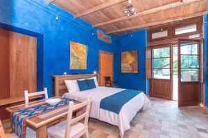 a blue bedroom with a bed and a wooden ceiling at La Pollona 1817 in San Maurizio Canavese