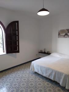 a white bedroom with a bed and a window at Villa magaggiari 2 in Cinisi