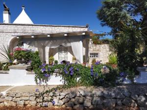 un jardin fleuri devant un bâtiment dans l'établissement Il Trullo di Nonno Angelo San Marco, à Locorotondo