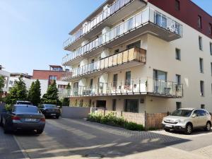 budynek z samochodami zaparkowanymi na parkingu w obiekcie Impresja 42 Apartament z garażem w Kołobrzegu