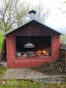 a red brick oven with a fire in it at Bosnian Hobbiton in Kovačevo Polje