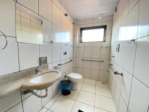 ein Badezimmer mit Waschbecken und Toilette in der Unterkunft Império Hotel in Caçu + 134 Fotos