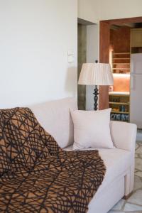 un sofá blanco con una manta y una lámpara en Skinos House en Vári