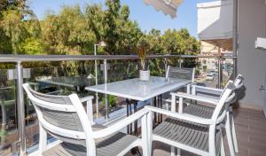 patio con mesa y sillas en el balcón en Rethymno Garden Suites en Rethymno