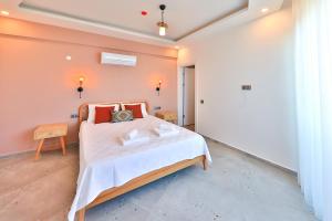 a bedroom with a bed with white sheets and red pillows at Happy Kaş Apart in Kaş