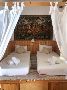 two beds in a room with a painting on the wall at Villa Soultana in Lindos