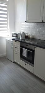 a kitchen with a black and white stove top oven at Apartament WIK-MAR in Elblag