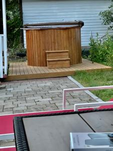 een houten terras met een bank in een tuin bij Villa Alex in Helsinki