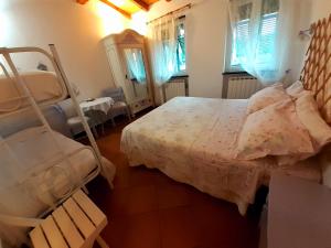 um quarto com uma cama, uma mesa e janelas em B&B I Glicini em Vescina