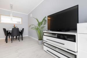 a living room with a flat screen tv on a white entertainment center at Przymorze Apartment Jagiellońska by Renters in Gdańsk