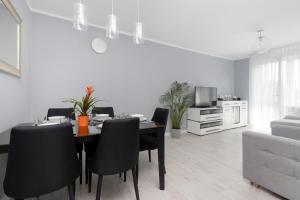 a dining room with a table and black chairs at Przymorze Apartment Jagiellońska by Renters in Gdańsk