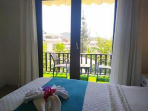 Schlafzimmer mit einem Bett und Blick auf einen Balkon in der Unterkunft Alya Hotel Göcek in Göcek