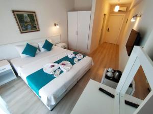 una camera da letto con un letto e asciugamani di Alya Hotel Göcek a Göcek