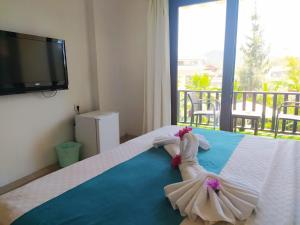 a little girl in a dress laying on a bed at Alya Hotel Göcek in Göcek +99 photos