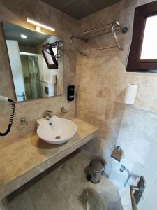 a bathroom with a sink and a shower at Alya Hotel Göcek in Göcek