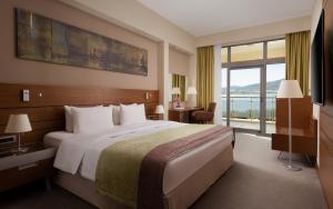 a hotel room with a large bed and a large window at Metropol Grand Hotel Gelendzhik in Gelendzhik