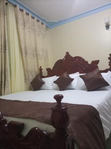 a bedroom with two large beds with pillows at Legend Executive Suites in Fort Portal
