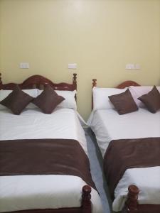 two beds sitting next to each other in a room at Legend Executive Suites in Fort Portal