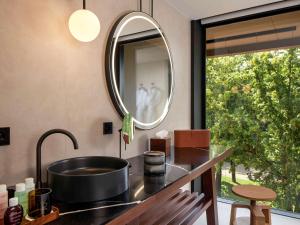 a kitchen with a sink and a mirror at L'Esquisse Hotel & Spa Colmar - Mgallery in Colmar