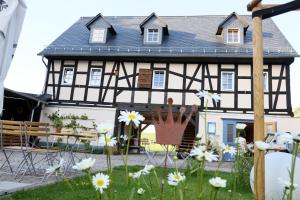a black and white house with flowers in the yard at Genusshof in Mülsen