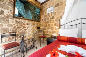 a bedroom with a bed and a stone wall at Cava d'Oro in Rhodes Town