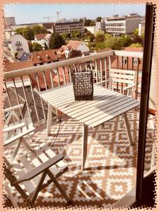 einen Holztisch und Stühle auf dem Balkon in der Unterkunft Square du Château in Schiltigheim