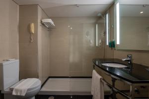 a bathroom with a sink and a toilet and a mirror at Vila Gale Cascais in Cascais