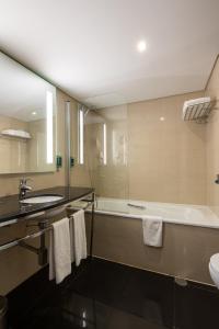 a bathroom with a tub and a sink and a bath tub at Vila Gale Cascais in Cascais