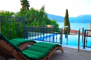 a green bench sitting next to a swimming pool at Leut Stone Residence in Tivat